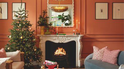 An orange living room with a Christmas tree and fireplace