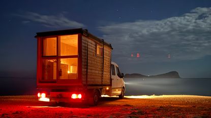 The COCOON-Freelancer by Attia Design – a mobile wooden cabin seen here on the back of a departing van at night