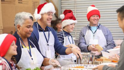 Volunteers wearing Santa hats serving food at a soup kitchen over Christmas