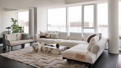 minimalist white living room with large white sofa and marble coffee table