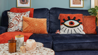 Orange cushions and furnishings on navy sofa