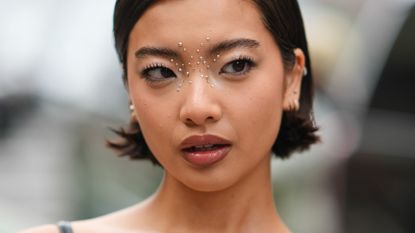 A woman at fashion week with strong eyebrows illustrating a guide to the best brow pens