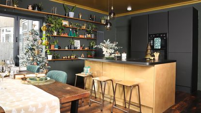 Black kitchen with gold island, bar stools and bi-fold doors