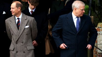 Prince Edward wearing a gray tweed coat looking to one side standing next to Prince Andrew wearing a navy coat looking the other direction