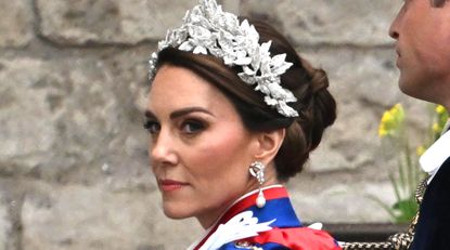 Kate Middleton wears a royal blue and red cloak and a glittering crown of leaves