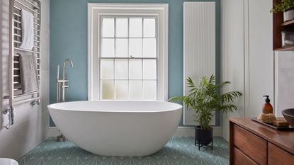 Blue and white bathroom with large curved bath