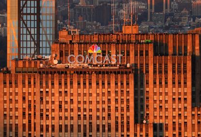 The sun sets on the Comcast corporate logo at the top of 30 Rock building in New York City