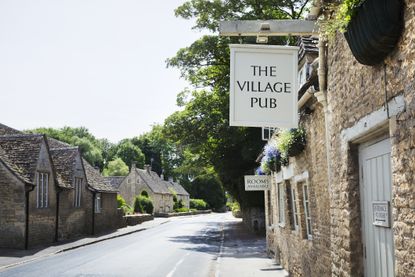 Exterior view of village pub with sign advertising available rooms