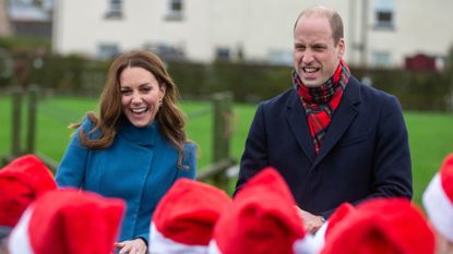 Kate Middleton wears a blue coat as she watches children wearing Santa hats alongside Prince William