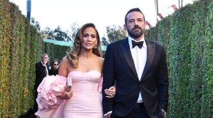 Jennifer Lopez wears a light pink strapless gown and Ben Affleck wears a tuxedo at the Golden Globes 2024