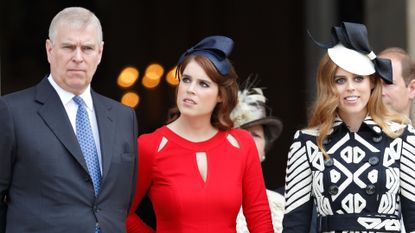 Princess Eugenie wears a bright red dress and a black ribbon on her head, while her sister Princess Beatrice wears a black and white patterned dress with a white hat featuring a black bow