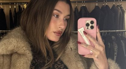 hailey bieber wears a fur coat and black lace top that showed her bra