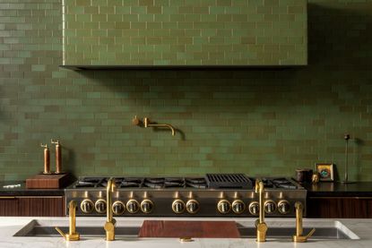 An olive green kitchen with tiled range hood