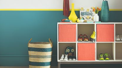 A two-tone painted hallway with a cubbyhole unit used for shoe storage