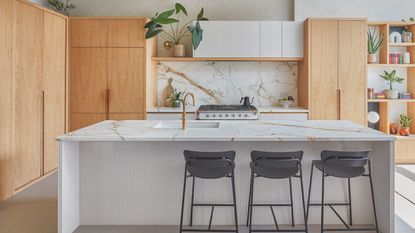 A modern London kitchen featuring wooden cupboards and marble splashback