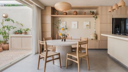 A clean and beautifully designed dining room and kitchen — with beige and cream accents