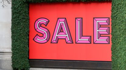 The store front of the London Selfridges store decorated for Christmas and with an entire window covered in a large red sale sign