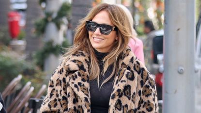 Jennifer Lopez walks in Los Angeles wearing a leopard print faux fur coat with a black turtleneck and jeans plus a black Birkin bag