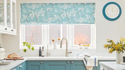 Bright white painted kitchen with blue cabinets and homey accessories