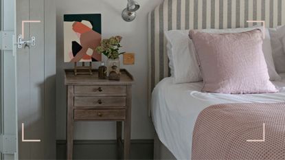 neutral bedroom close-up of the bed next to a wooden side table to support advice on what you need to know before buying a mattress