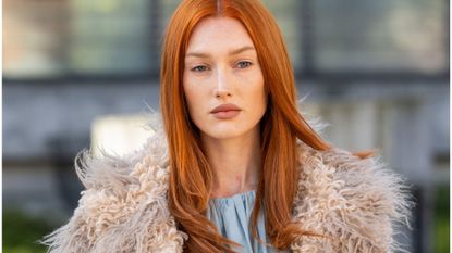 A street style shot of a woman with auburn hair 