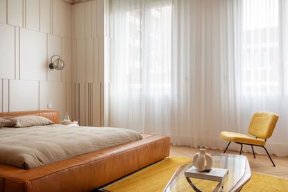 a bedroom with closed curtains and a large leather bed