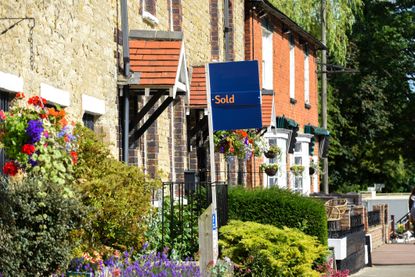 House for sale sign reading sold by estate agent or real estate letting