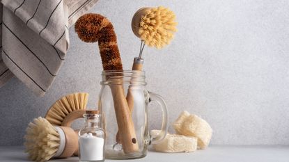 A glass jar filled with natural bamboo cleaning tools