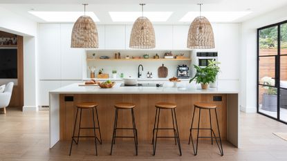 White kitchen and worktop with kitchen island and bar stools