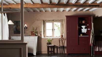 Pantry in rustic cottage with low beamed ceilings, original windows, large freestanding burgundy pantry and white antique sideboard