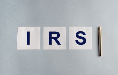 the letters IRS on a table next to a pen