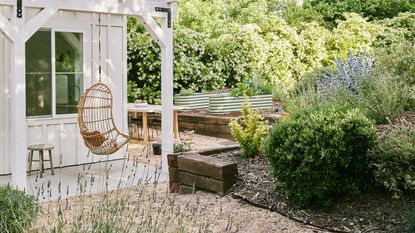 sustainable garden design with gravel, mulch, planting and swing chair