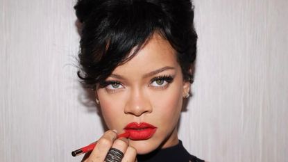 Rihanna wearing her signature red lip with a beehive updo