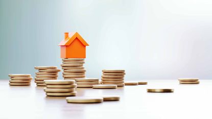 tiny orange house on stack of coins