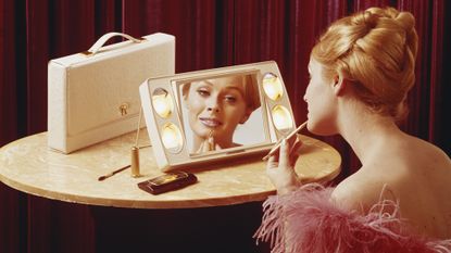 Archive picture of woman putting on make-up in front of a mirror