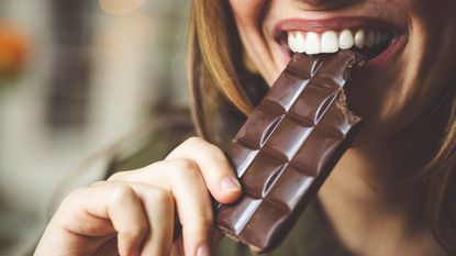 Woman eating bar of dark chocolate