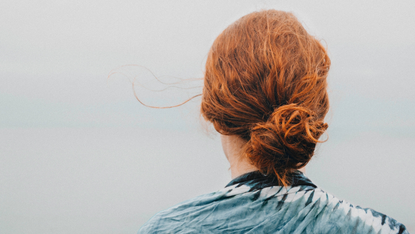 Person with red hair tied in bun