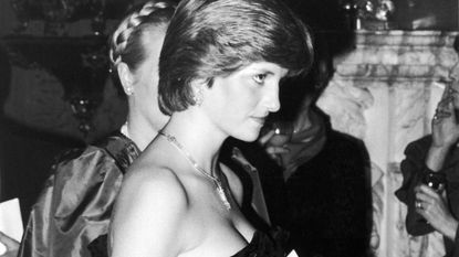 A black and white photo of Princess Diana wearing a black strapless dress