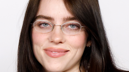 Billie Eilish wearing glasses and posing 