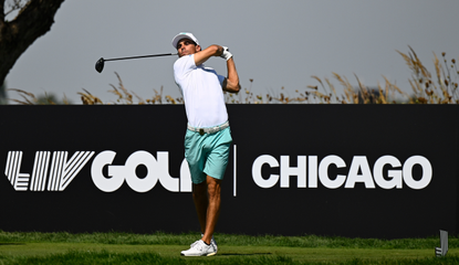 Joaquin Niemann hits a tee shot in front of a LIV Golf Chicago board