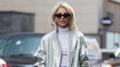 Caroline Daur walking in New York wearing silver jacket and black sunglasses - best texturising sprays