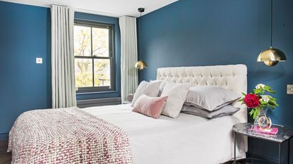 Blue bedroom with grey curtains and white bed