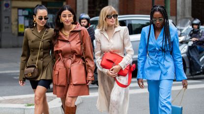 Anna Rosa Vitiello wearing cycle pants, olive double breasted jacket, Fendi bag, Bettina Looney wearing rusty brown coat, boots, Xenia Adonts wearing red Fendi bag, creme white dress, Chrissy Rutherford wearing blue jacket and pants seen outside the Fendi show during Milan Fashion Week Spring/Summer 2020 on September 19, 2019 in Milan, Italy.