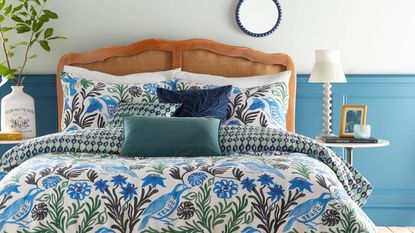 A bedroom with blue and white walls and a blue and green patterned duvet cover