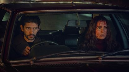 Ben Whishaw as Sam and Keira Knightley as Helen, sitting in the front seats of a British car (with blood on Helen&#039;s face), in &#039;Black Doves.&#039;