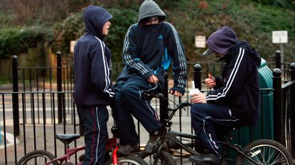 Young persons in hooded tops gather on a housing estate east of Bristol city centre 