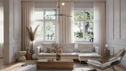 A bright, neutral living room with modern, minimalist furniture and large windows with sheer white curtains