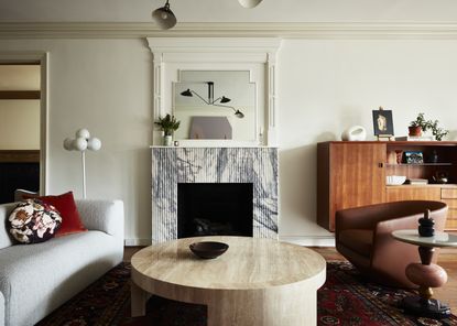 A living room with a built-in fireplace, a curving sofa and two armchairs 