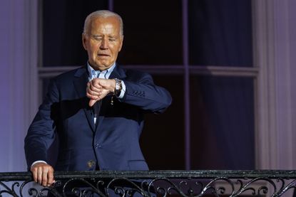 President Joe Biden looks at his wristwatch