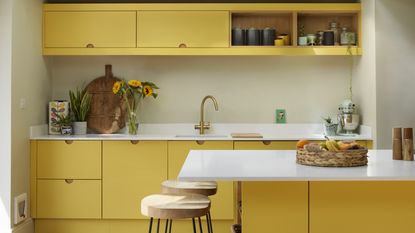 Yellow kitchen with slab doors and island